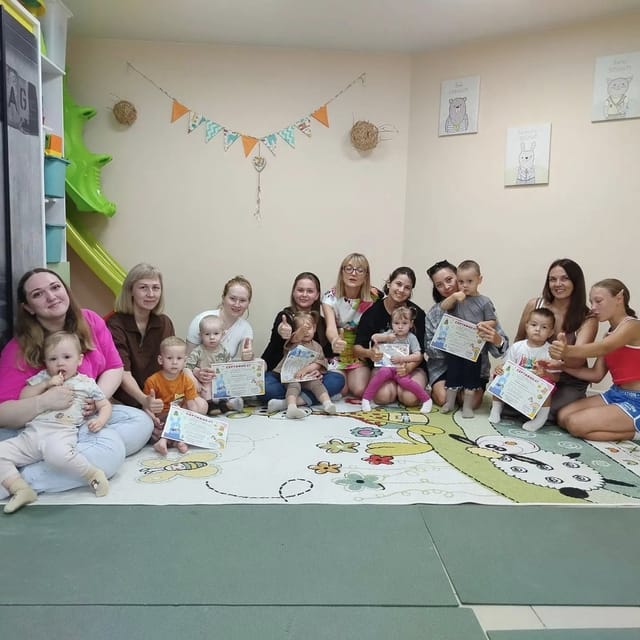 Мамы с малышами сидят в кругу